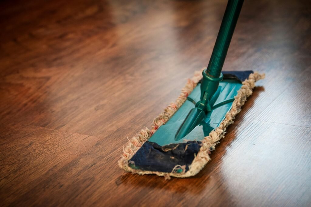 cleaning washing cleanup the ilo 48889 48889 A detailed view of a mop cleaning a wooden floor, showing texture and pattern.