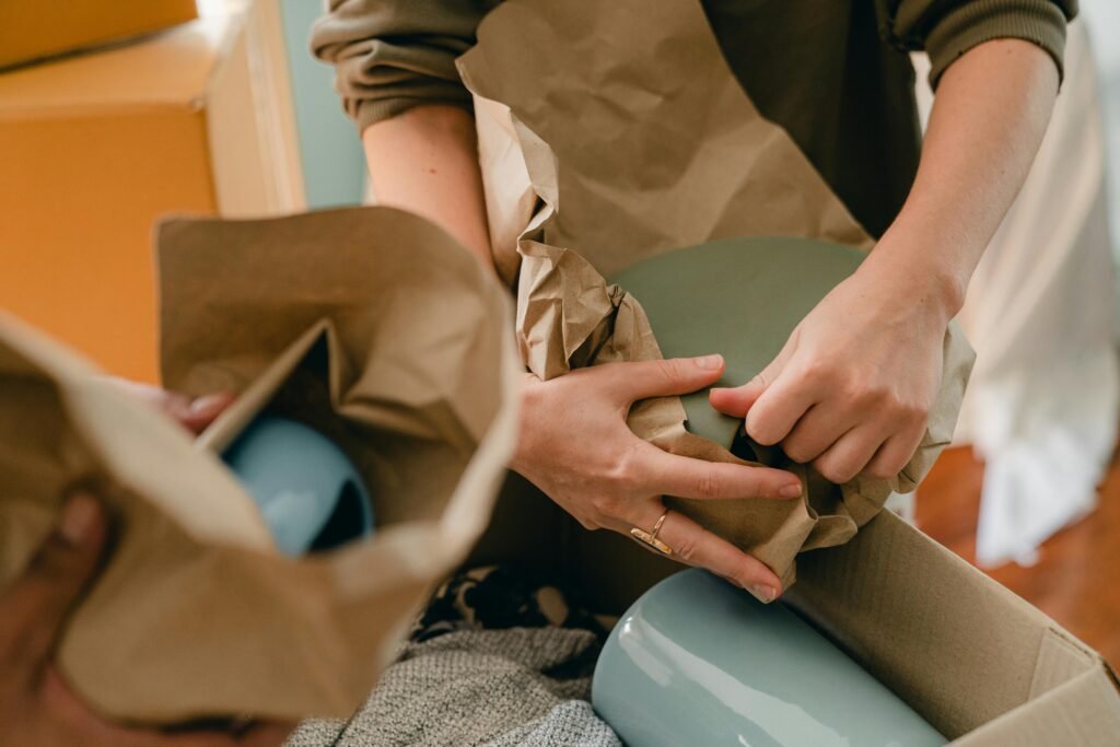 pexels photo 4246187 4246187 Closeup of hands carefully unwrapping ceramic items during a moving process indoors.